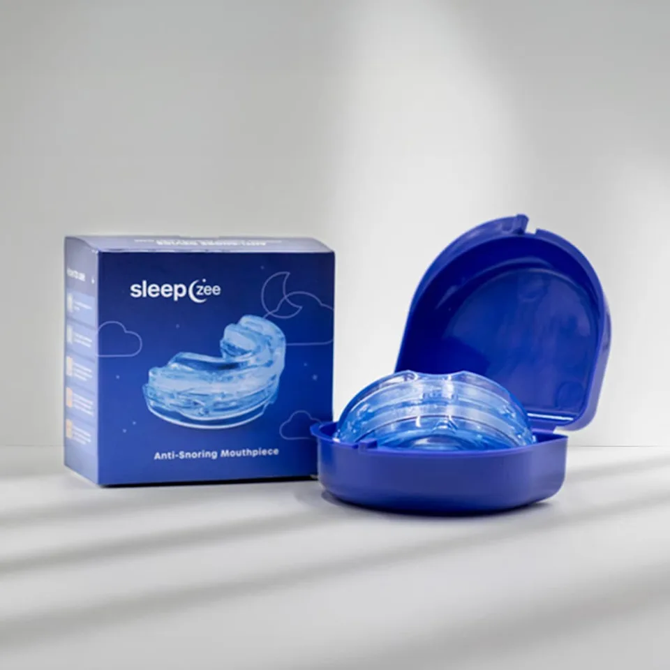 Woman sleeping peacefully at night with an anti-snoring mouthpiece beside her bed, representing restful sleep and improved nighttime comfort.