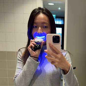 Woman using the Orbicare 360° Ultrasonic Toothbrush with a hands-free mouthpiece design for quick daily cleaning, ultrasonic vibrations, and portable rechargeable oral care.
